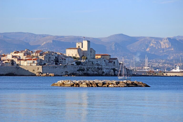 La vieille ville d’Antibes et le château Grimaldi au bord de la mer, avec les montagnes des Préalpes en arrière-plan